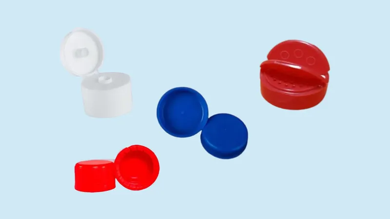 Tapas de plástico blancas, azules y rojas, entre ellas una tapa flip top abierta y varias tapas de rosca